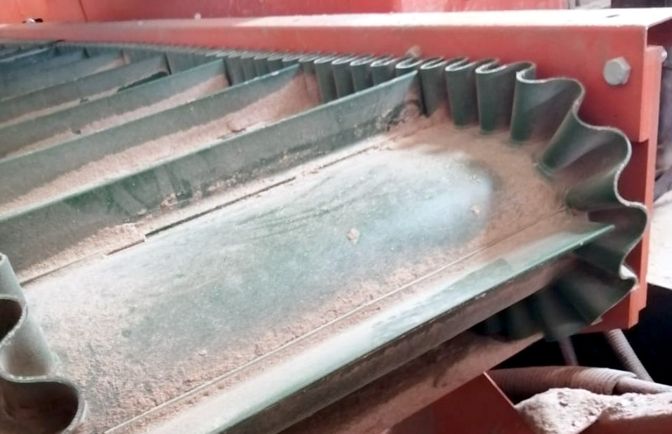 Belt draping over drum with corrugated edges and paddles